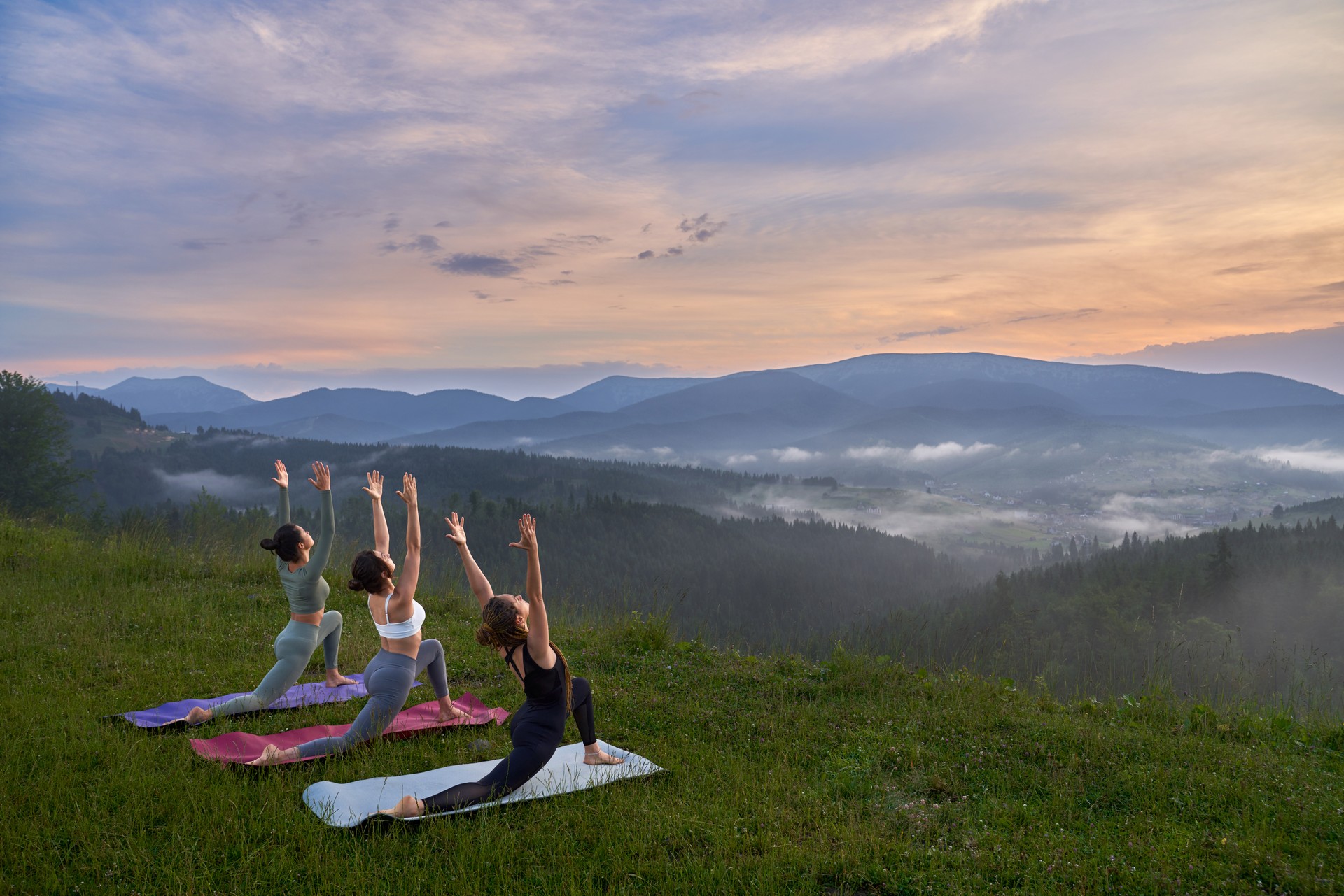 Fitness women doing yoga exercises among nature